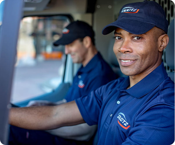 Ductz workers smiling in cab of work van