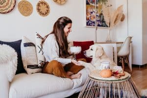 Woman and her dog enjoy a clean, cozy home after completing the fall home maintenance checklist