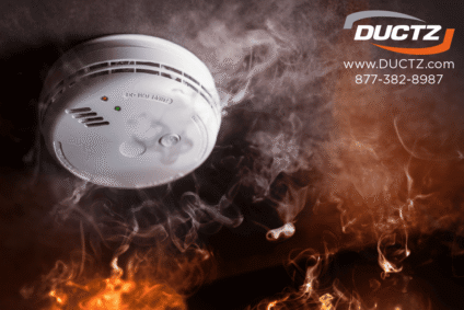 Smoke detector surrounded by smoke and flames